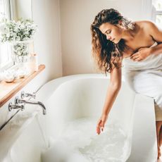woman sitting on the side of a bath - best bath products