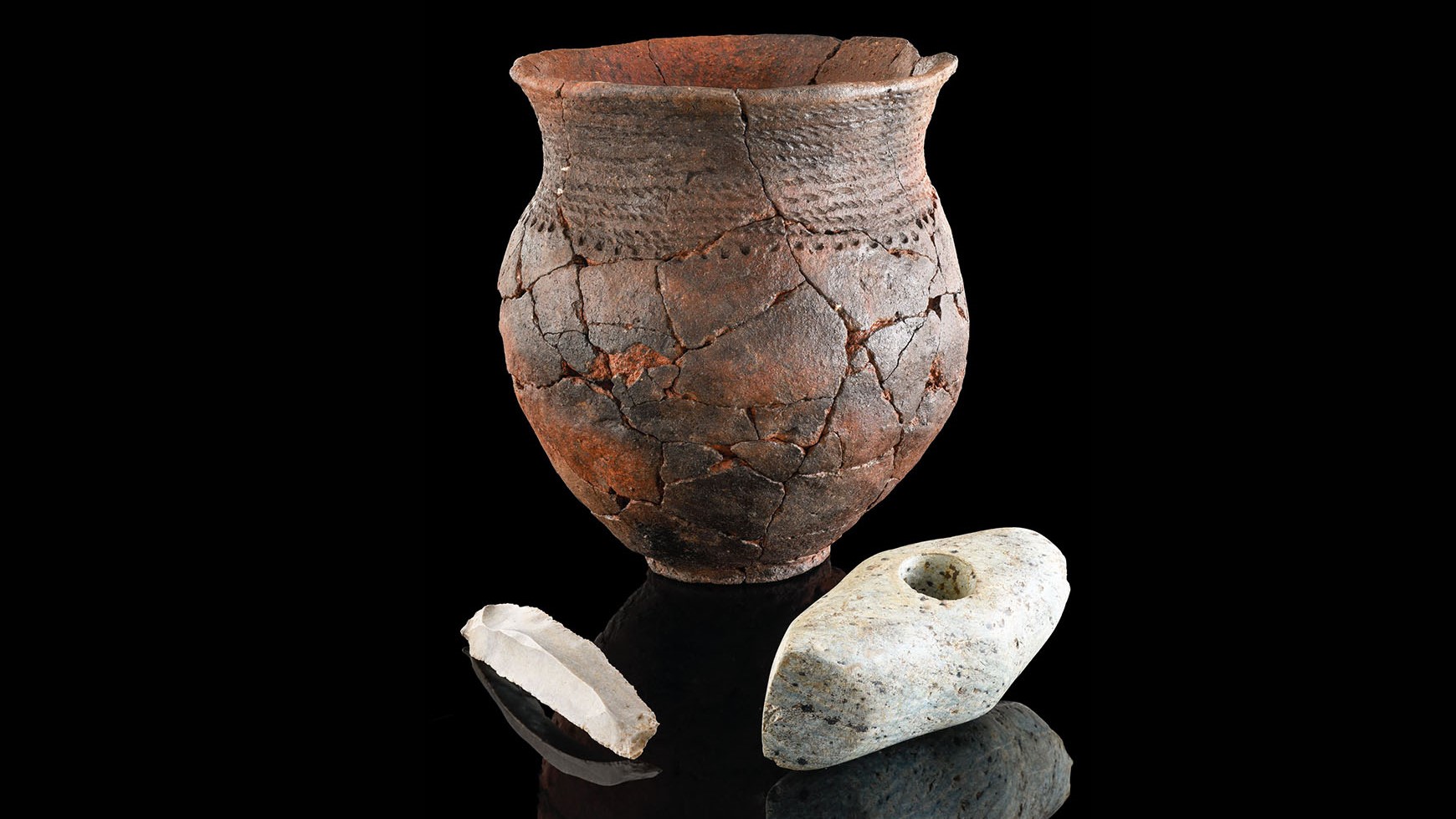 A corded ware pot, rock ax, and flint blade from a Stone Age grave found in southwestern Germany.