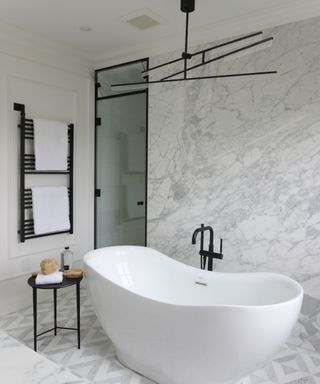 bathroom with freestanding bath and gray tiles
