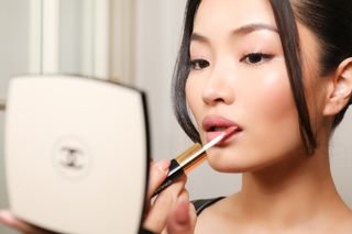 Anna Sawai applies chanel makeup while getting ready for the chanel haute couture show in paris
