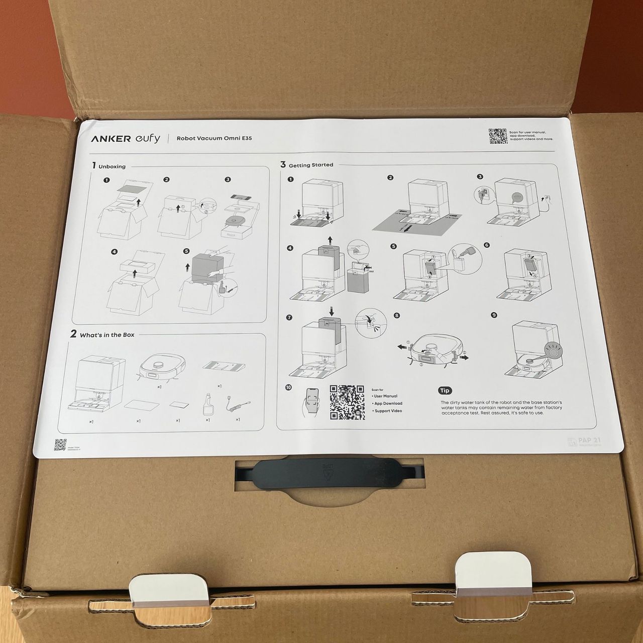 Inside the box of the Anker eufy Robot Vacuum E35 Omni, showing the quick guide on top of cardboard packaging