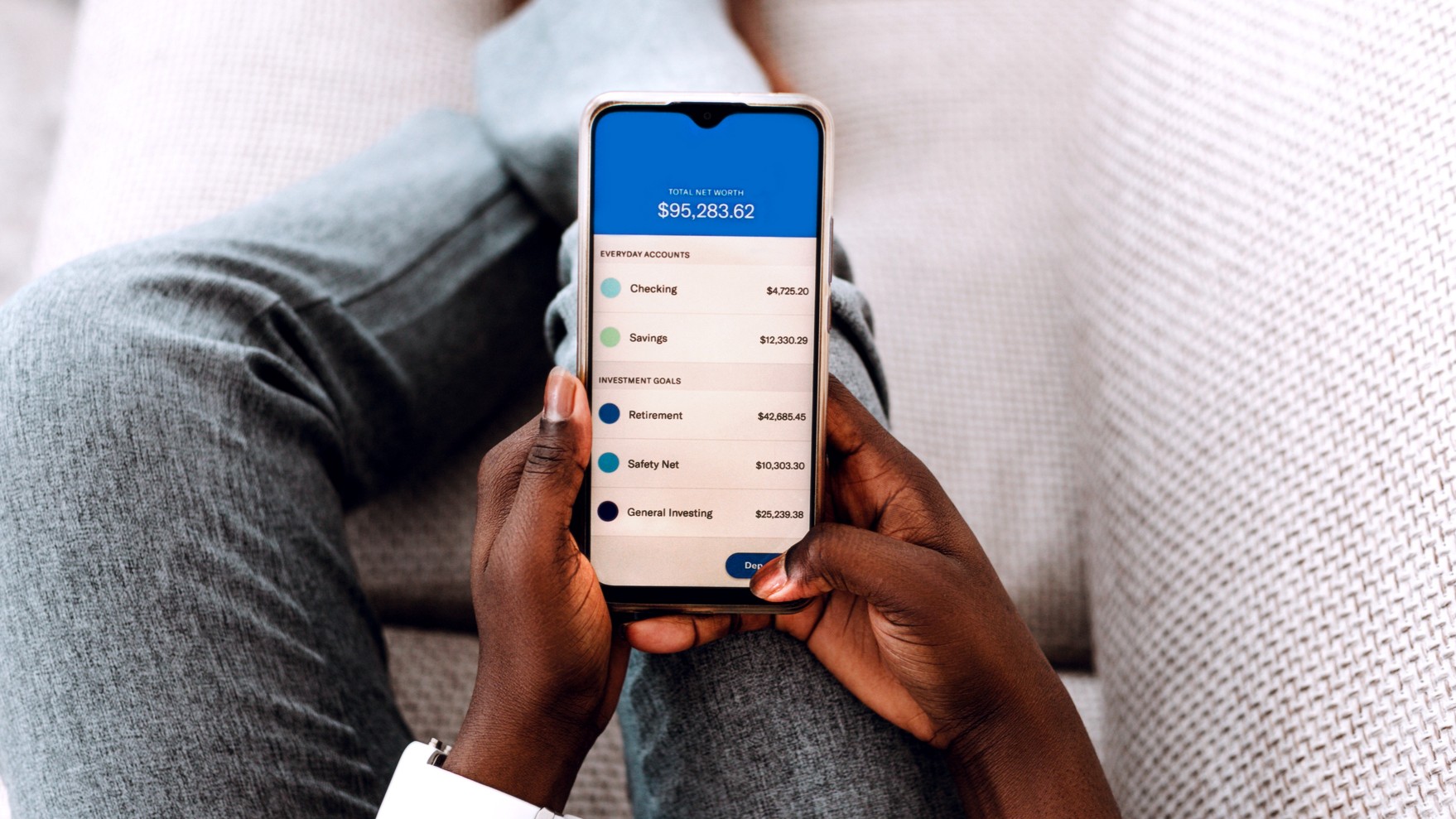 Hands hold a phone checking account balances on an online bank. 