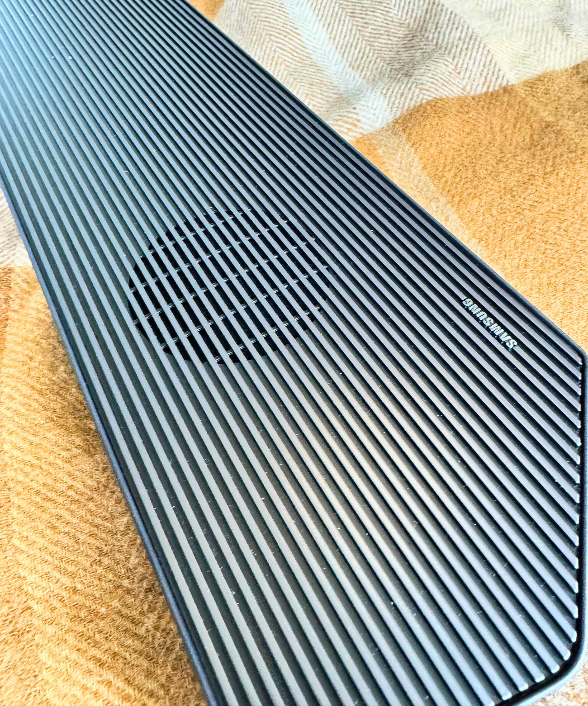 Samsung HW-Q990F soundbar and brown checked blanket.