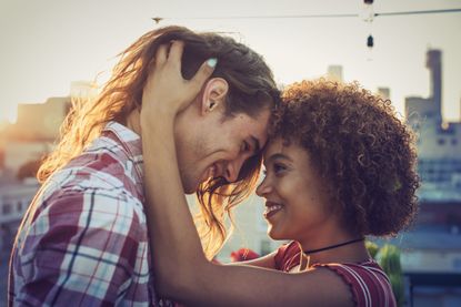 Couple in a serious relationship embracing on urban rooftop 