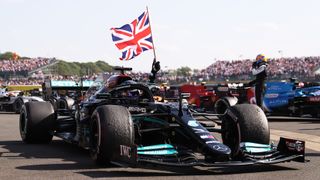 Race winner Lewis Hamilton of Great Britain and Mercedes AMG F1 celebrates by flying the Union Jack flag from his race car's cockpit during the F1 British Grand Prix at Silverstone.