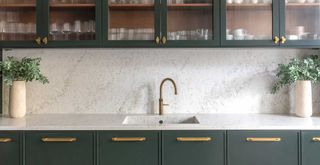 dark green kitchen with white marble countertop and splashback
