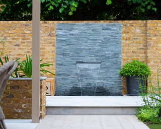 modern wall water feature in garden designed by Tom Howard