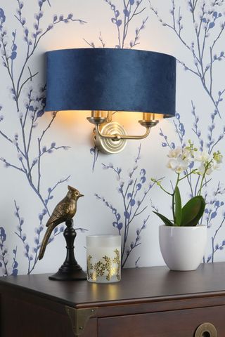 blue wall light on wallpaper with side table