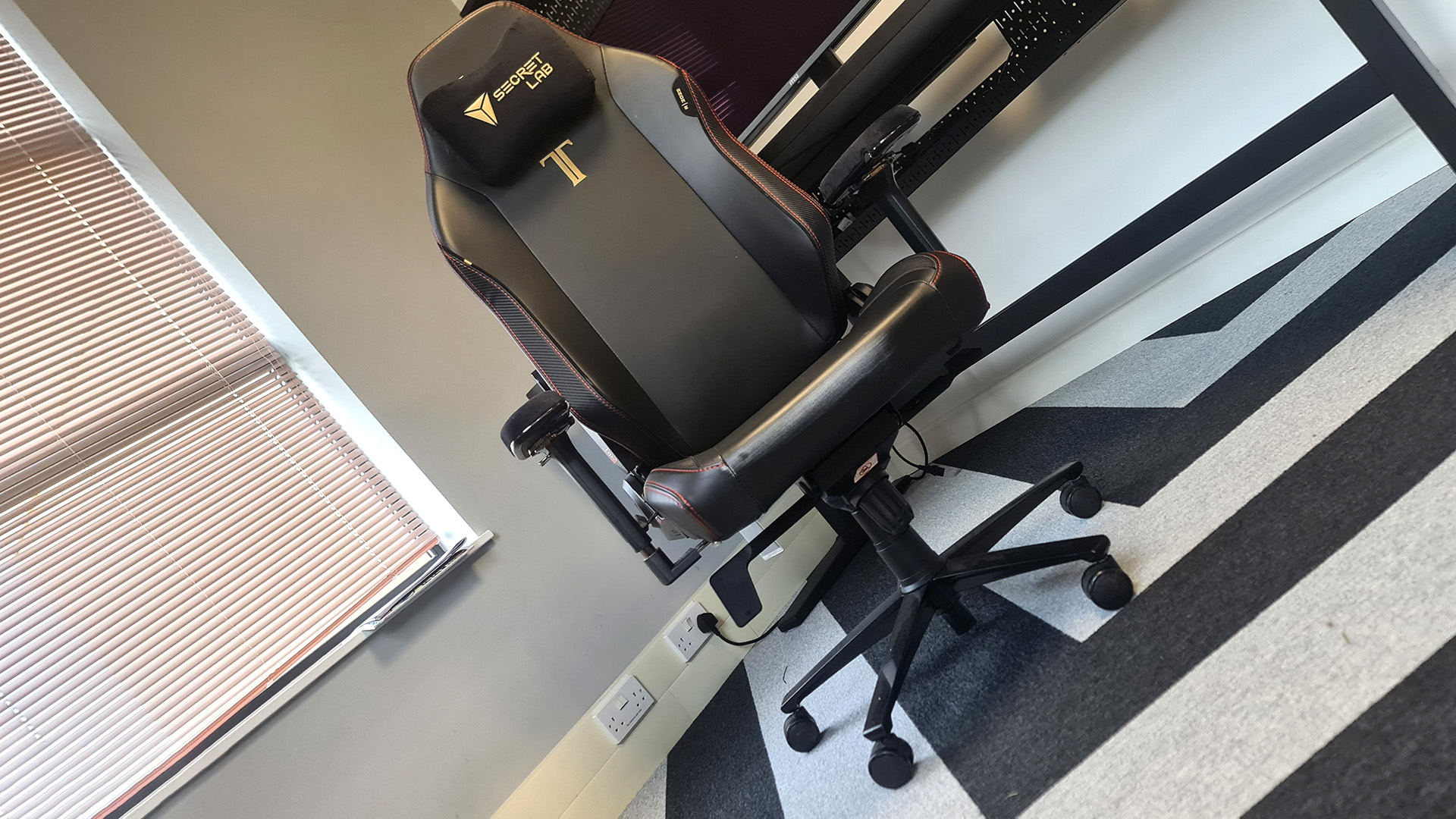 The Secretlab Titan Evo next to a desk in the PC Gamer office.