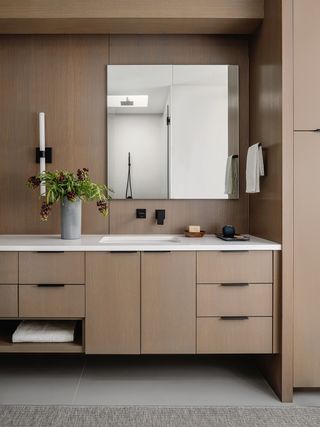 brown bathroom cabinets and big mirror