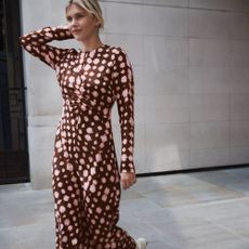 Woman against a stone wall wearing a Hush dress