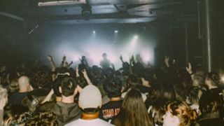 A shot of a crowd during a packed show in a small music venue.