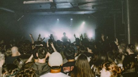 A shot of a crowd during a packed show in a small music venue.