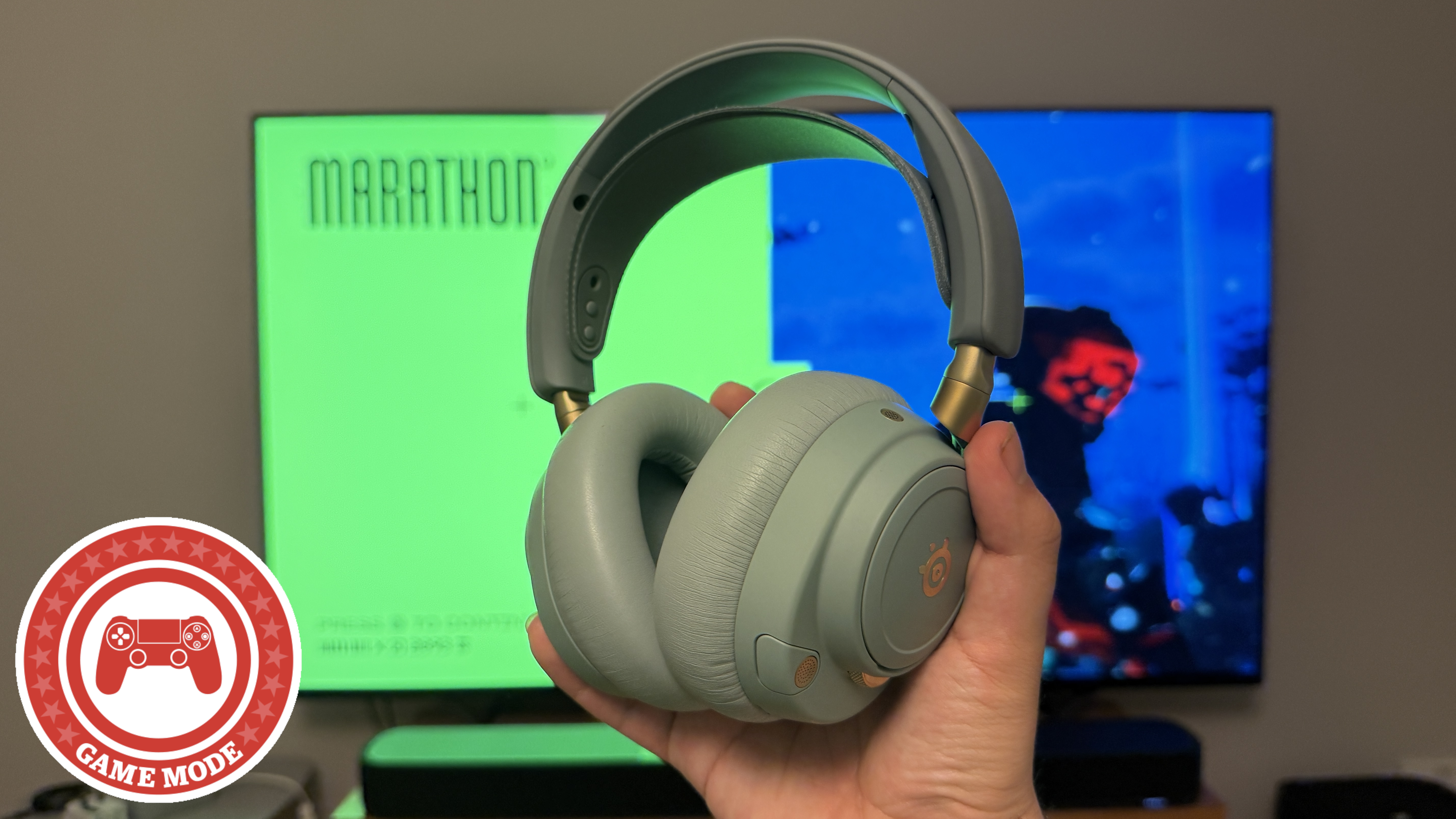 A hand holding a SteelSeries gaming headset in front of a TV with the video game Marathon on screen