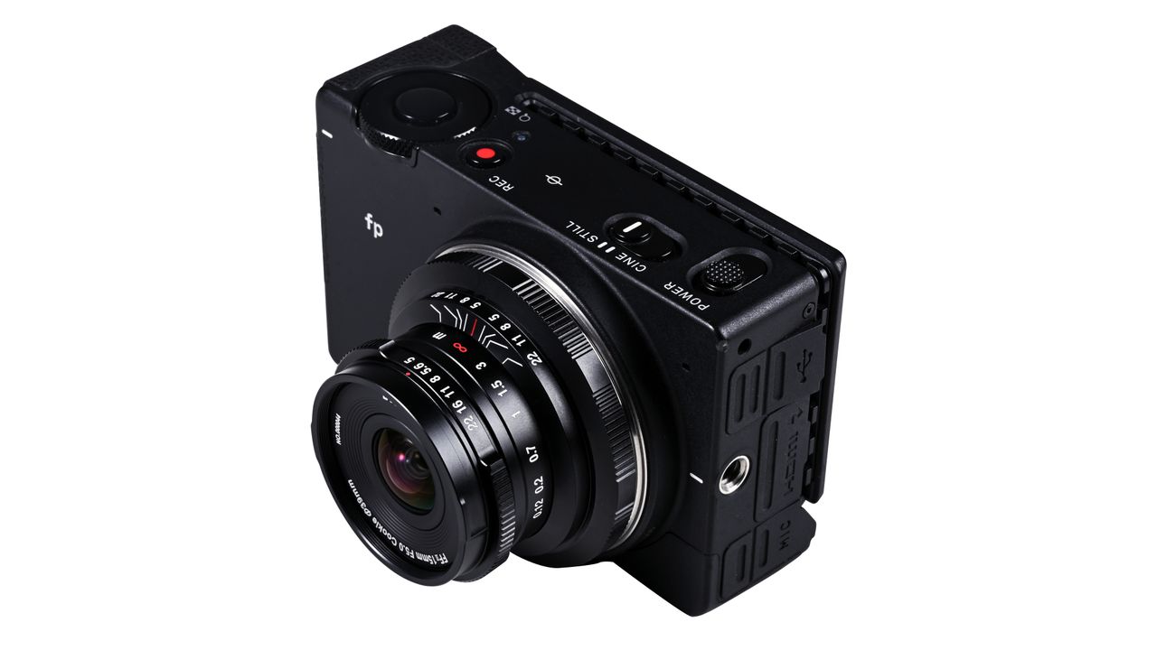 Laowa 15mm f/5 Cookie FF lens, mounted to a camera, against a white background