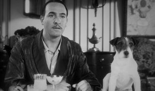 Jean Dujardin and Uggie sitting at the breakfast table in The Artist.