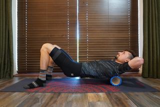 Image shows rider using a foam roller on his upper back.