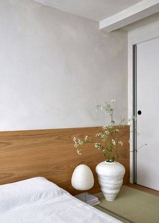 A Japanese style bedroom with a paper lantern and a large vase