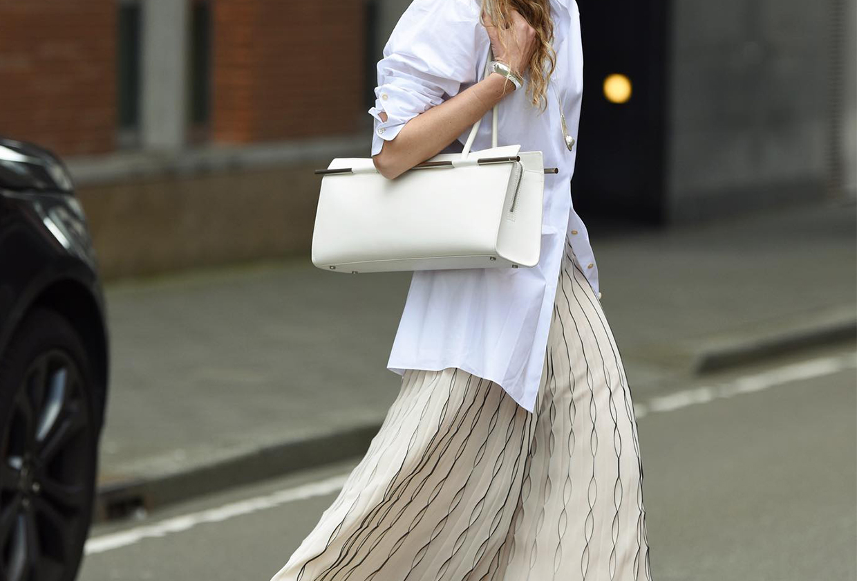 A fashion person wearing a white poplin shirt and a skirt