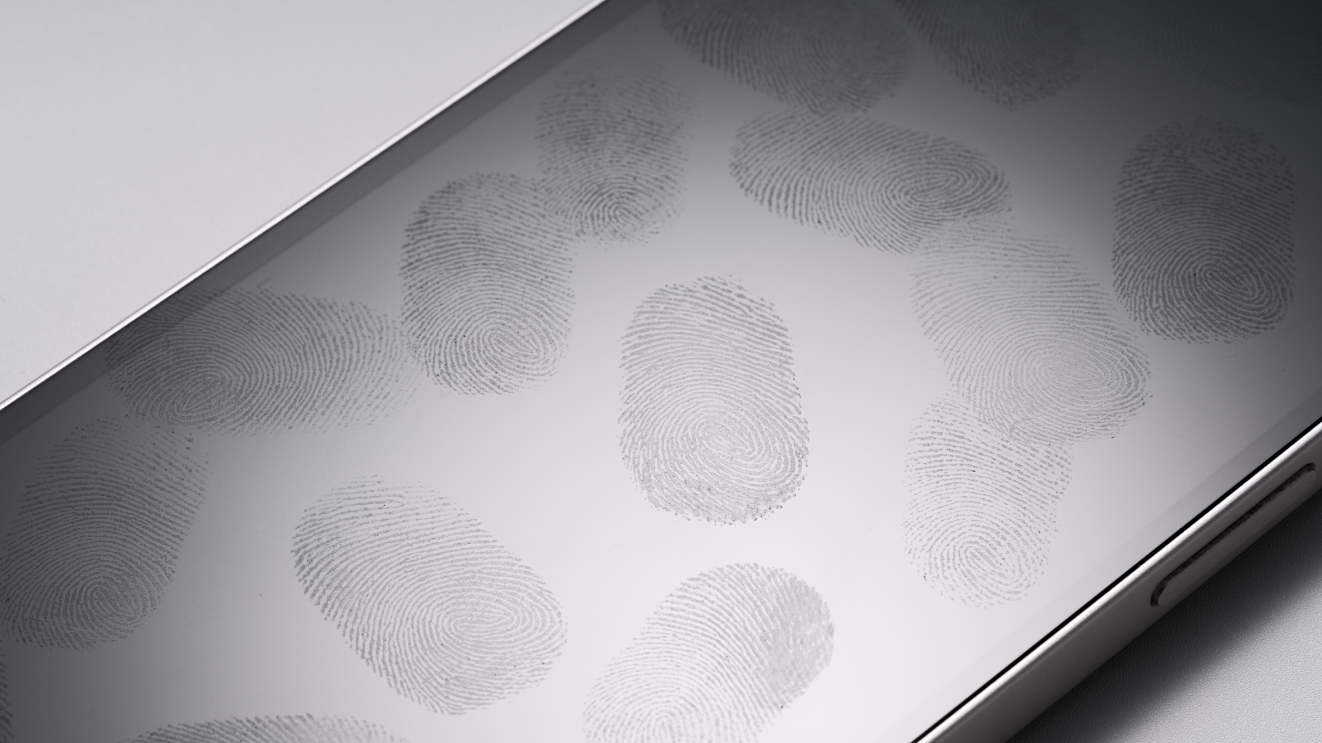 Many Fingerprints on Phone Screen Against White Background High Angle View.