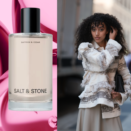 A woman with curly hair wearing a ruffle top, holding a clutch with two bottles of hair perfume on her left and right. 