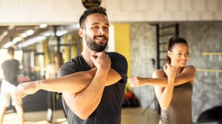 Bästa träningsappar: En man och en kvinna som tränar tillsammans inne på ett gym.