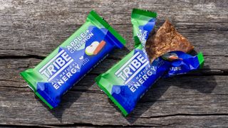 A pair of Tribe energy bars on a wooden bench