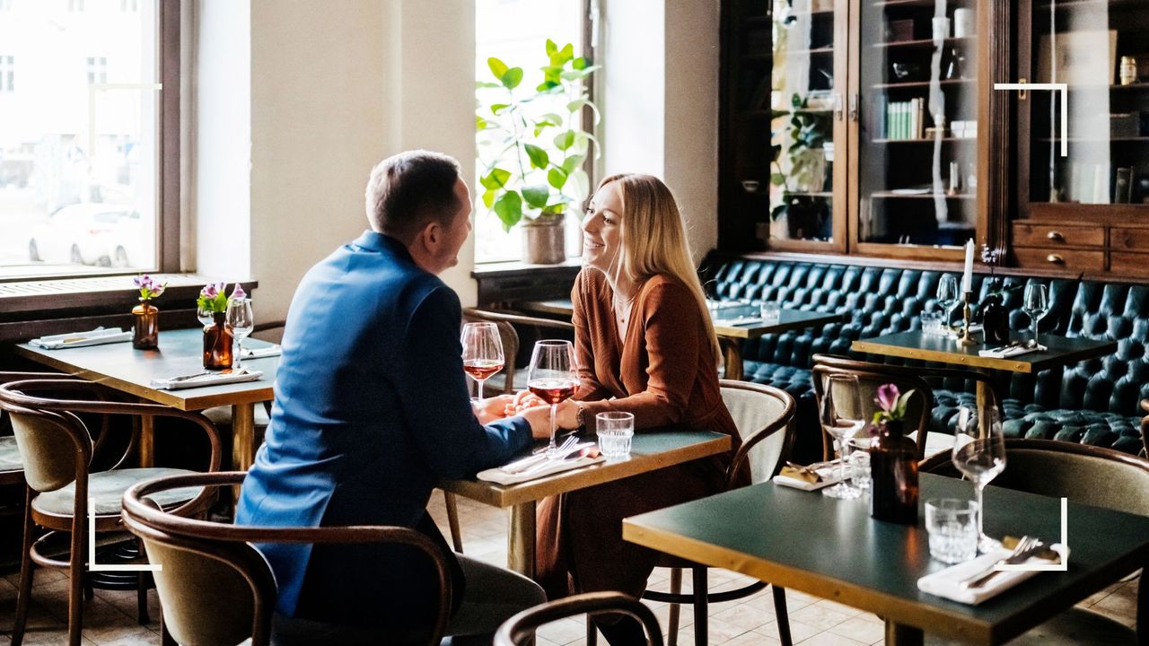 A couple at a restaurant laughing and smiling together after learning how to spice up your relationship