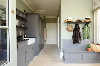 A large mudroom with grey storage and hooks for coats used as an example of designing a mudroom