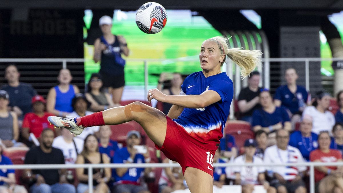 Women&#039;s US Olympic soccer team captain, Lindsey Horan, jumps for the ball in the US home strip.