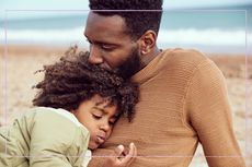 A father and son hugging on a beach