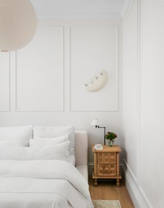 minialist bedroom with white bed and wood nightstand