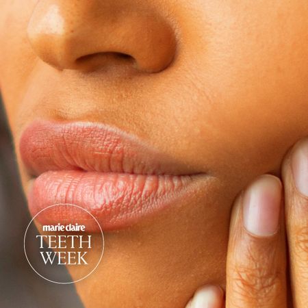 a close up of a woman's jaw and lips, and she is holding up a hand to her chin as if she is in pain