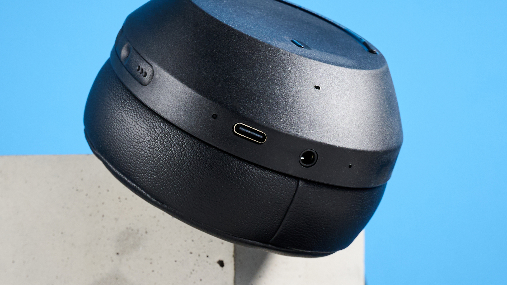 the mixx streamq c4 headphones in black with a blue background showing the soft cups and buttons controls