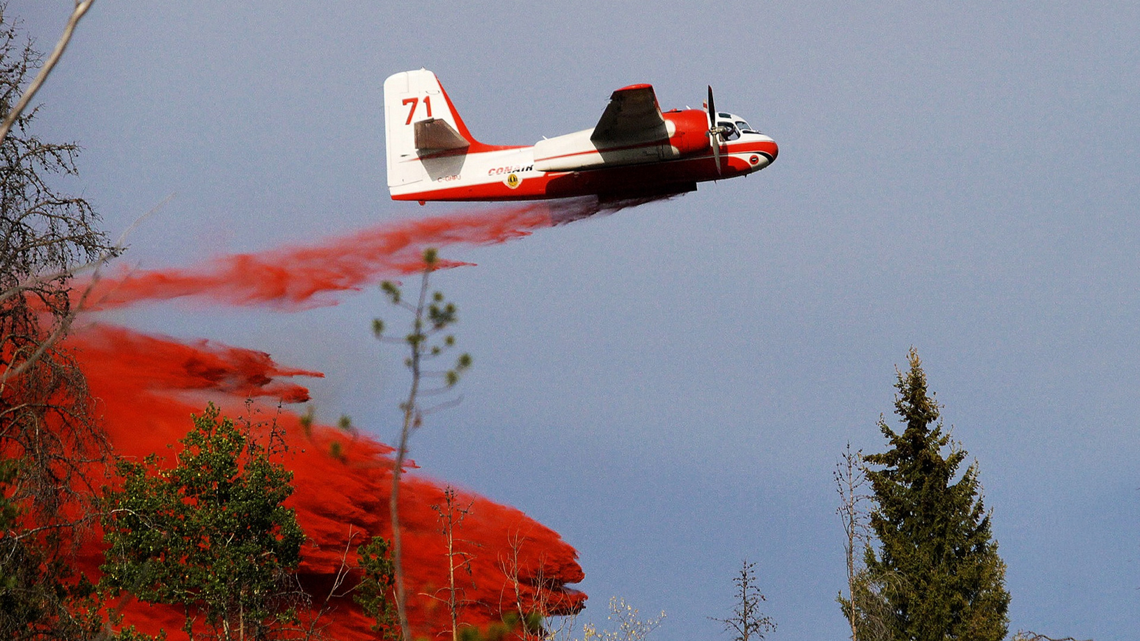 Plane dropping red retardant on wildfires in Canada