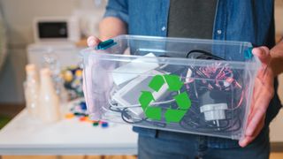 Man holding recycling box containing waste electronics