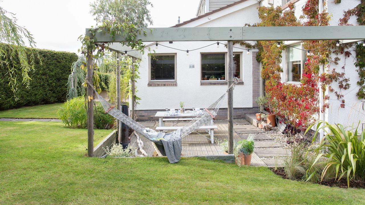 A garden with a house and a hammock