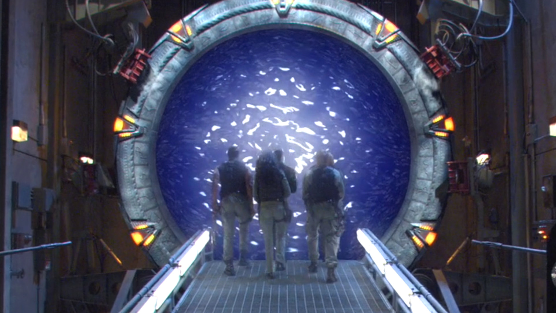 Three soldiers walking through a Stargate during an episode of Stargate SG-1.