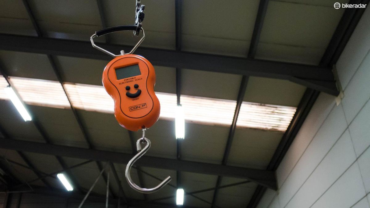 A weighing scale hangs from the high ceiling by an old bike chain &ndash; essential equipment to make sure the bikes are UCI compliant