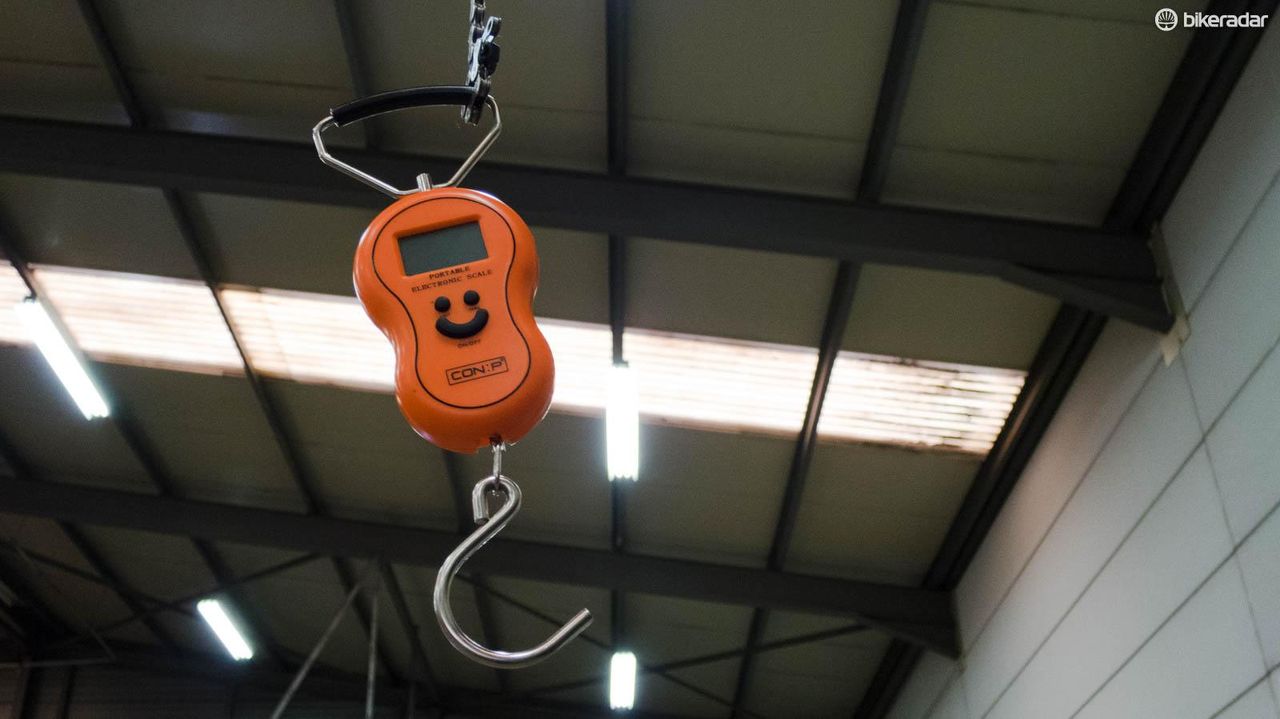 A weighing scale hangs from the high ceiling by an old bike chain &ndash; essential equipment to make sure the bikes are UCI compliant