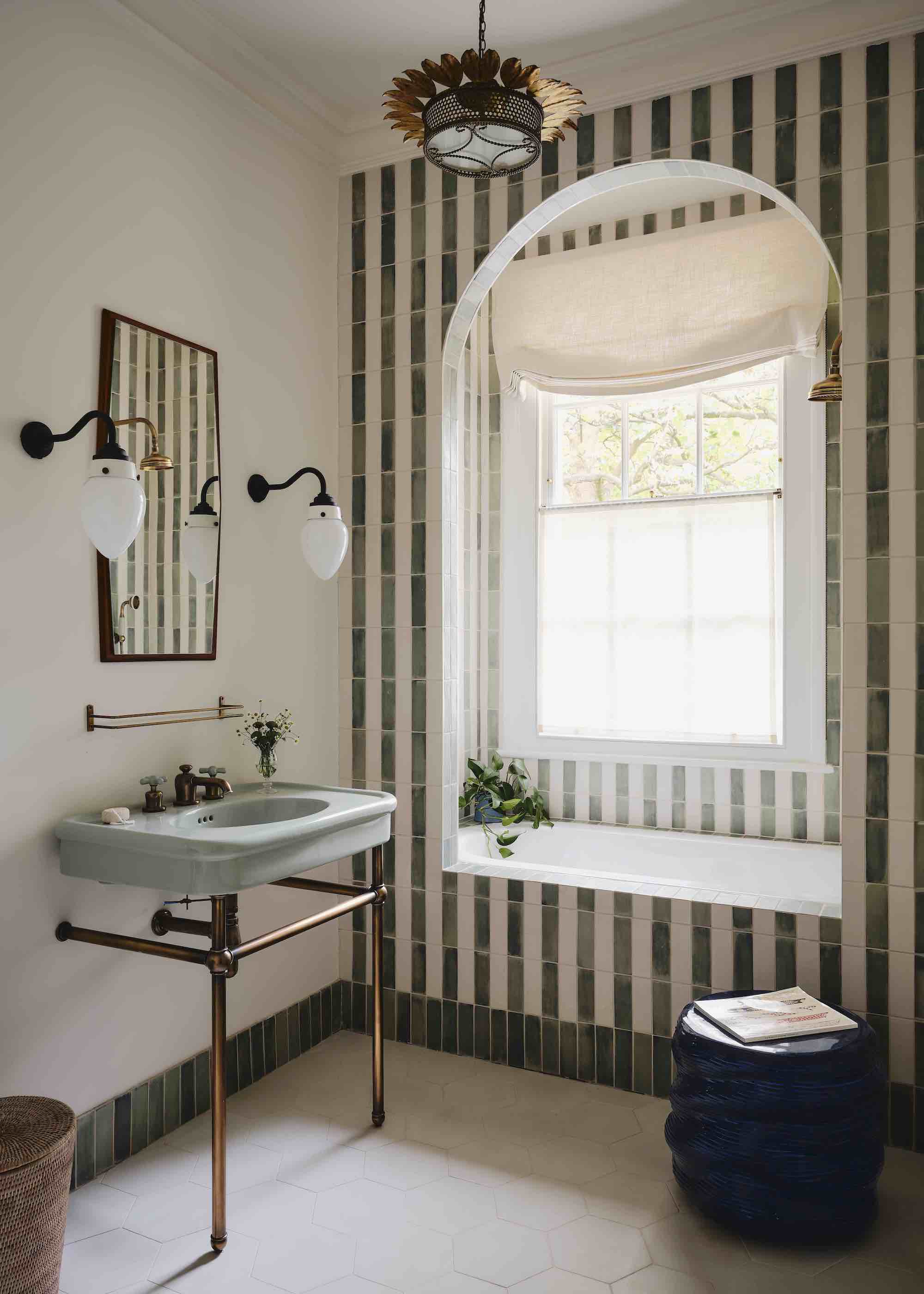 bathroom with arched bathing nook clad in striped tiles
