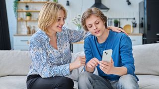 Parent with teenager looking at phone