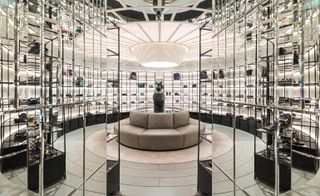 Luxury footwear room, with the circle sitting area in beige at the center, surrounded by mirror shelves that display the footwear.