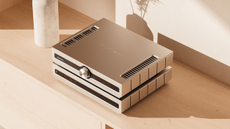 Angled photo of Roksan Caspian Streaming Pre-Amplifier and Power Amplifier on top of a light coloured wooden sideboard