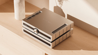 Angled photo of Roksan Caspian Streaming Pre-Amplifier and Power Amplifier on top of a light coloured wooden sideboard