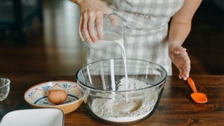 Can you freeze cheese? Image of woman baking with milk and eggs