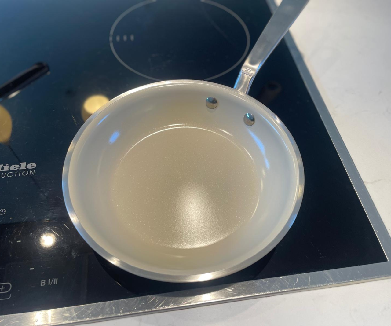 Made In CeramiClad&trade; Non-Stick Frying Pan on a black stovetop.
