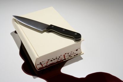 Book with bloody knife on top of it.