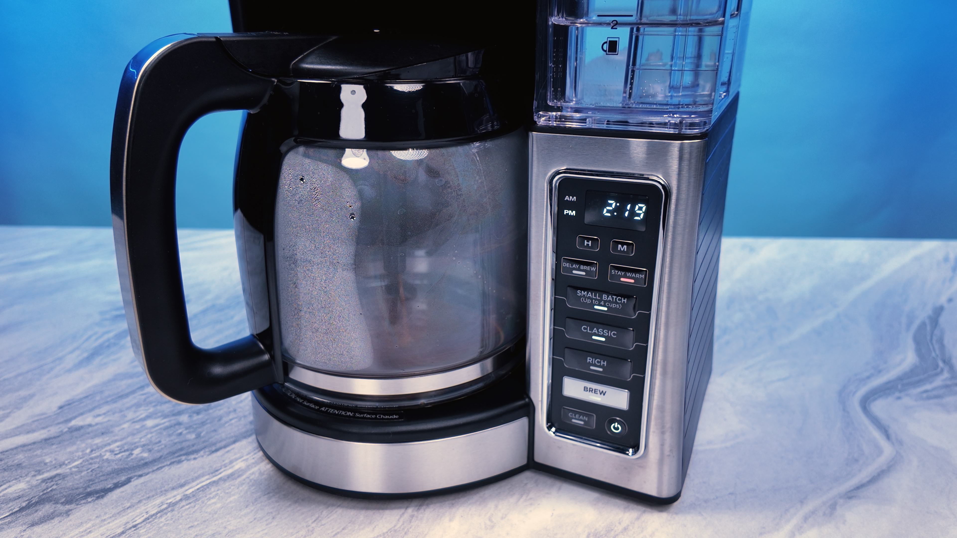 the ninja 12 cup brewer coffee maker with a blue background making coffee
