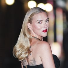 Scarlett Johansson wearing a black tank top and brown pants